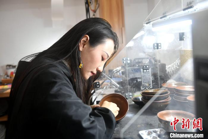 在唐潔工坊內(nèi)，“90后”文物修復師瞿汕正低頭忙碌?！蚊?攝
